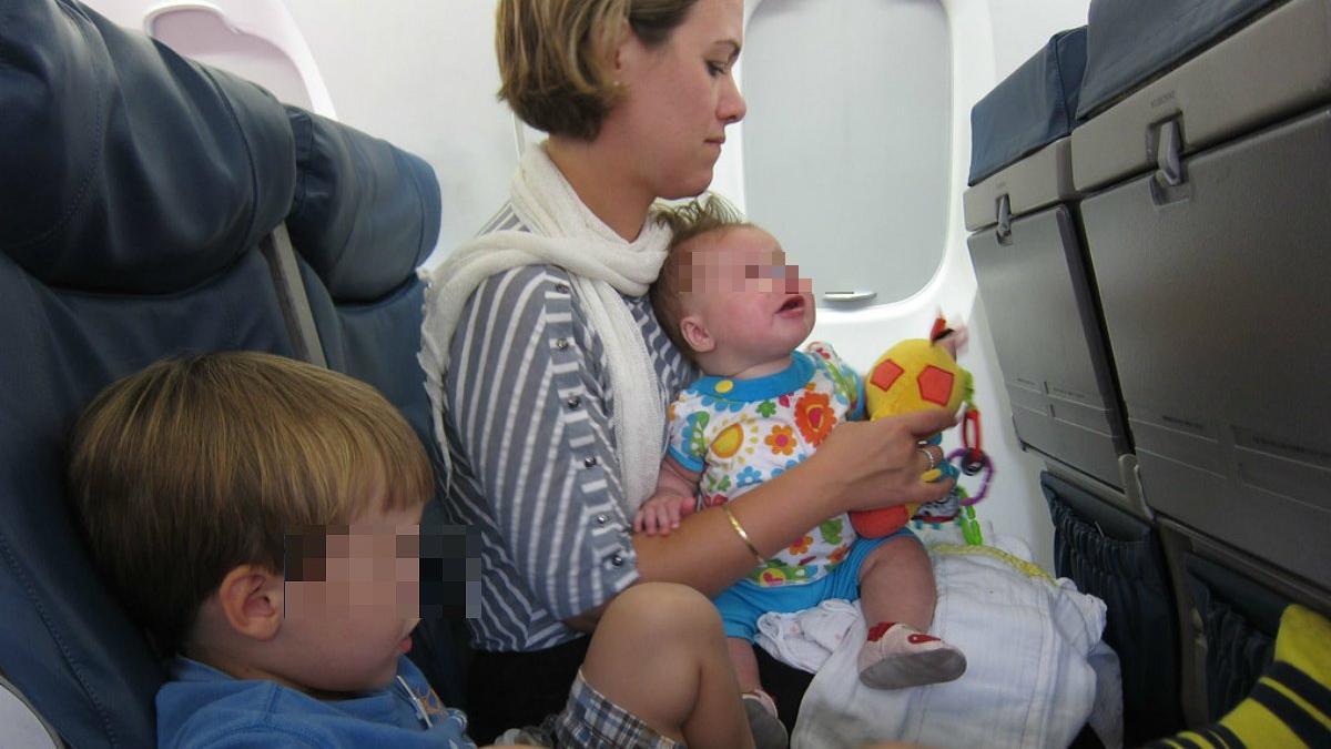 Una madre con sus hijos, viaja en avión.