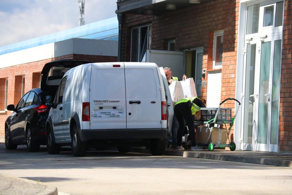 Dos agents de la Guàrdia Civil entrant caixes i bosses durant el registre a la planta potabilitzadora de Montfullà, a Bescanó