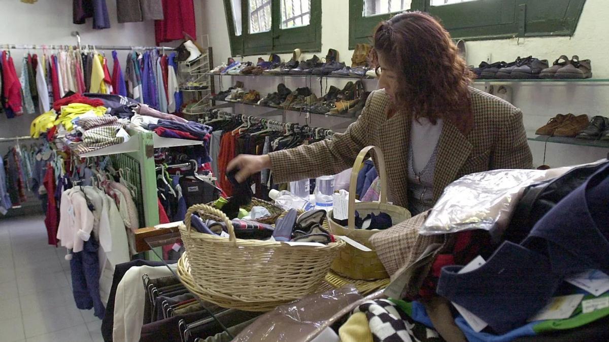 Una mujer examina ropa de segunda mano