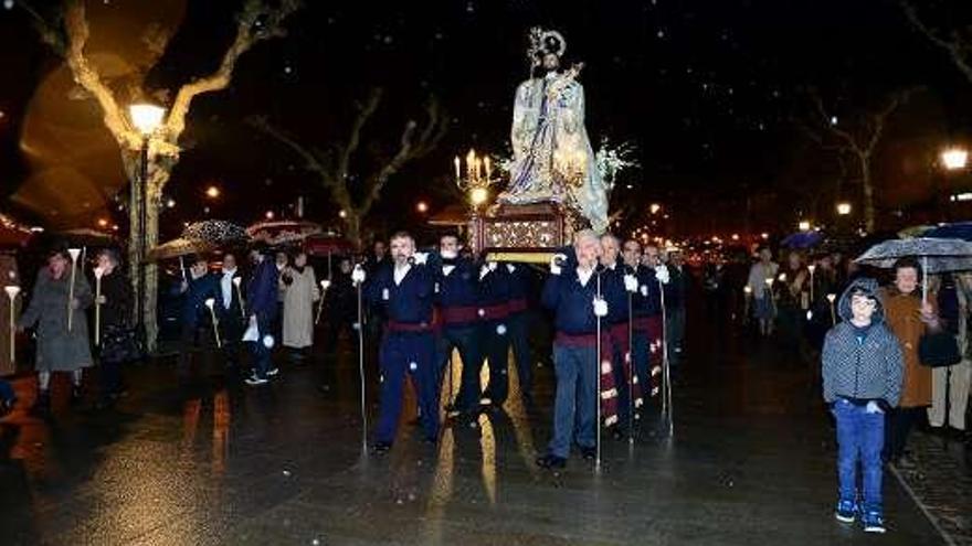 La segunda parte de la procesión de San José se celebró bajo la lluvia. Arriba y a la izquierda, la imagen en procesión. Abajo, los fieles con paraguas.  // Gonzalo Núñez