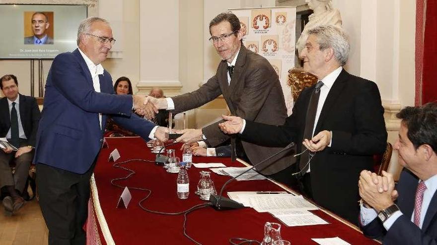 Ruiz Ezquerro recoge el premio de manos de José Ramón Ara, vicepresidente de la Sociedad de Neurología.