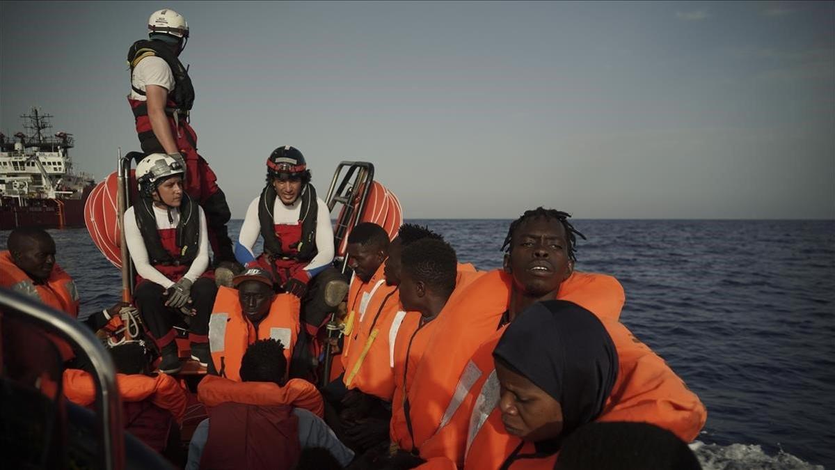 Un grupo de migrantes rescatados en el Mediterráneo son llevados al 'Ocean Viking', este miércoles.
