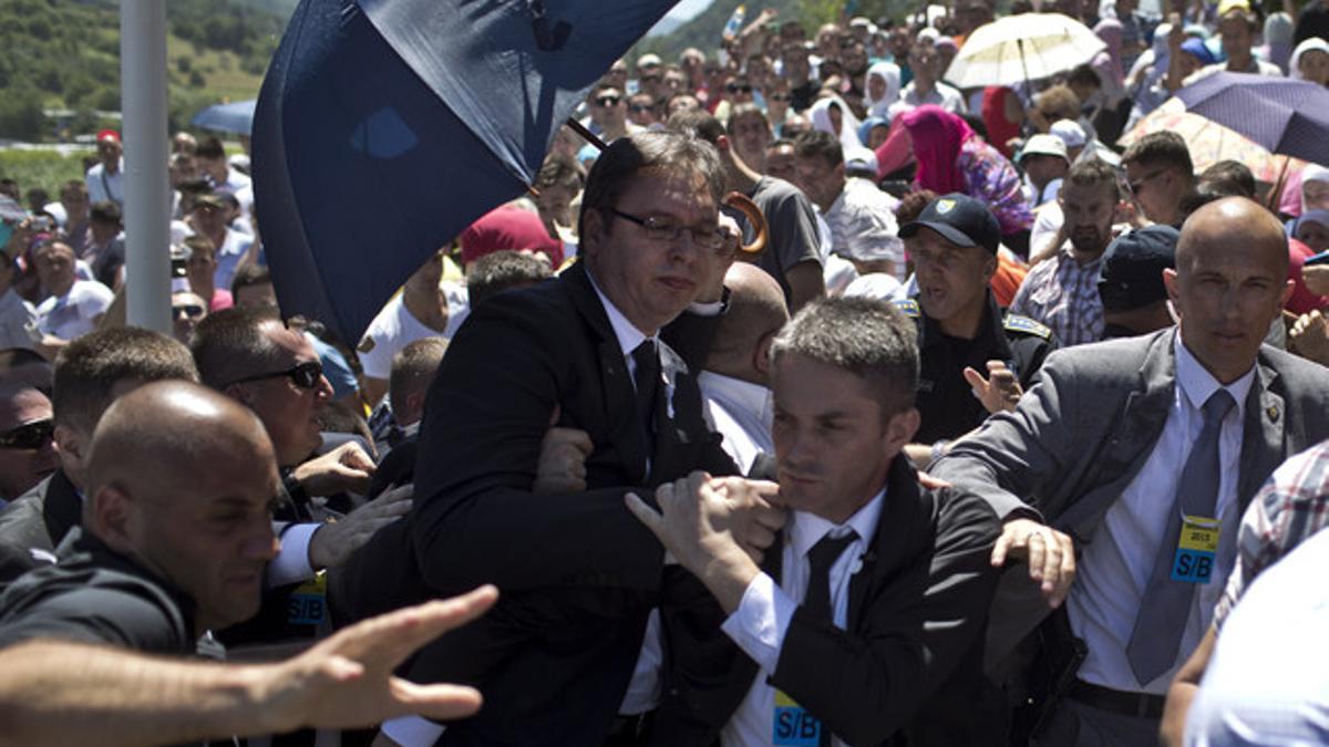 Aleksandar Vucic, primer ministro serbio, protegido por sus guardaespaldas en el momento de ser agredido en el homenaje a los muertos en la masacre de Srebrenica