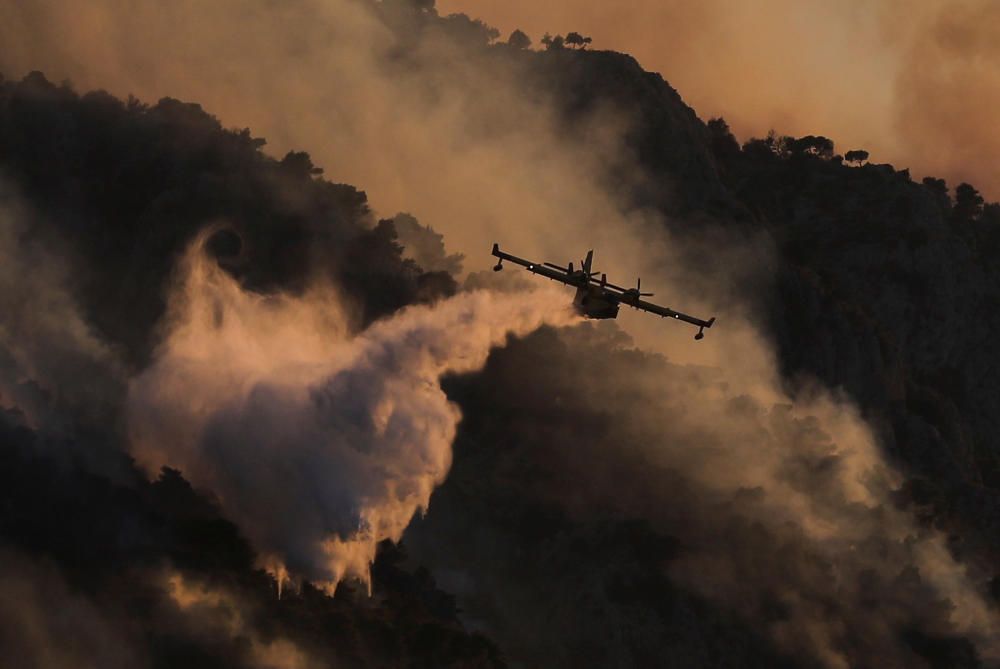 Un avión lanza agua sobre un incendio cercano a Kechries, en Grecia.  Foto:REUTERS