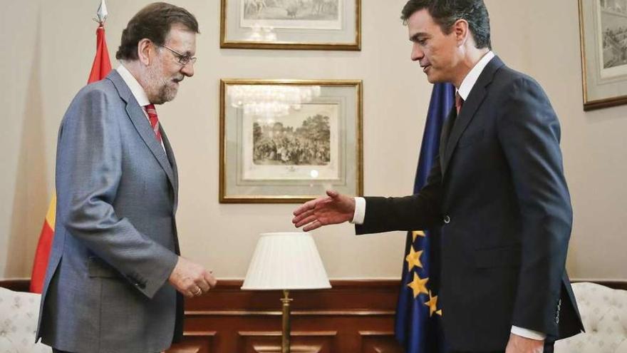 Rajoy y Sánchez, ayer, a punto de darse la mano, antes de la reunión. // Efe