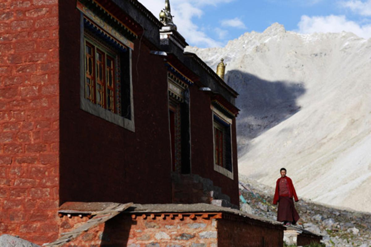 Un monjo tibetà al costat de l’entrada del temple budista de la muntanya Kailash a Ngari (Tibet).