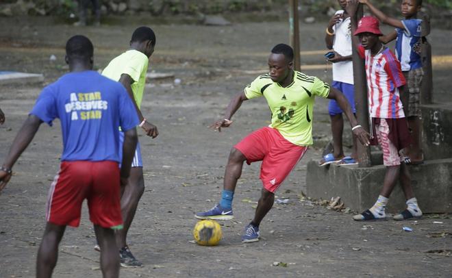 Prince J. Blimie (L) controla un balón durante la práctica en una calle de Monrovia, Liberia.