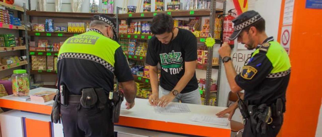 Una patrulla de la Policía Local de Elche realizando una inspección a uno de los establecimientos de venta de artículos pirotécnicos que ha abierto para las fiestas.