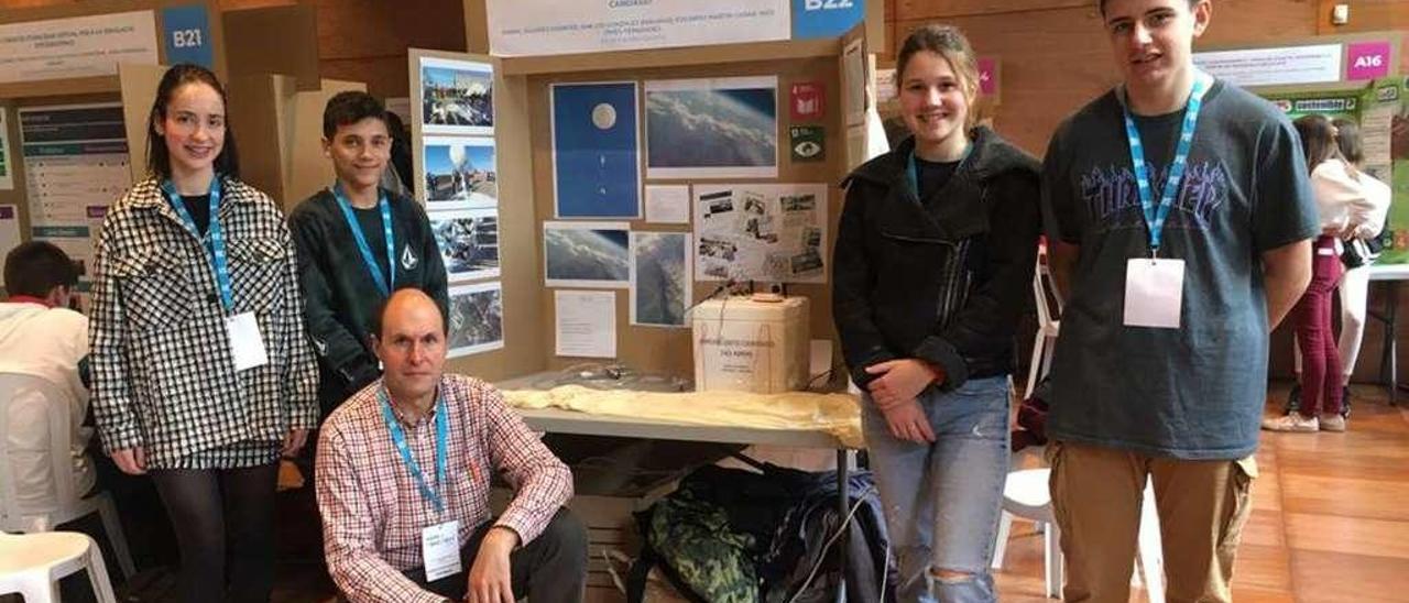 Por la izquierda, Les González, Eduardo Martín, Inés Ovies y Aníbal Álvarez, con su profesor, Javier Redondas (agachado), con la exposición de su proyecto &quot;Candasat&quot; en la Feria de la Ciencia de Barcelona.