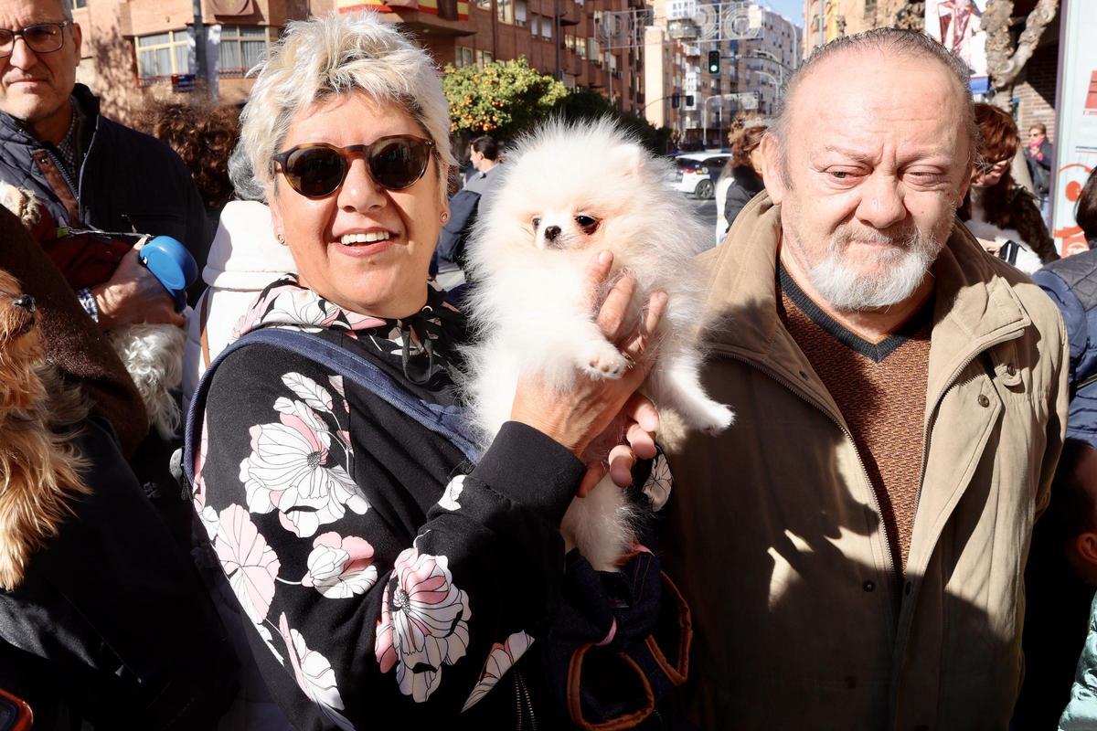 Lola sostiene a su perro, Lolo, en la puerta de la ermita de San Antón de Murcia.