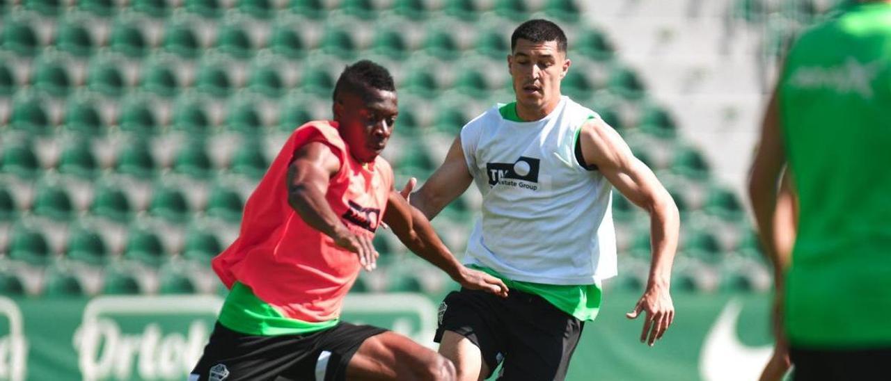 Helibelton Palacios lucha por un balón con Diego González, durante el entrenamiento del lunes