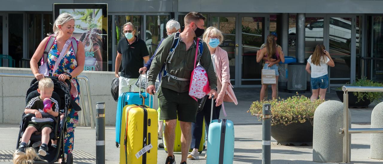 Varios turistas salen del aeropuerto de Ibiza.
