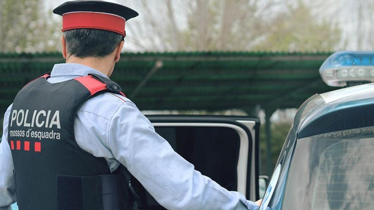 Un agente junto a un vehículo de los Mossos d'Esquadra.