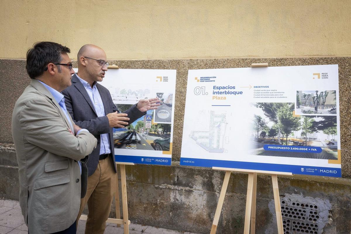 El delegado de Políticas de Vivienda del Ayuntamiento de Madrid, Álvaro González (izqda.) y el director general de Regeneración Urbana, Raúl Monte, ante un panel sobre el proyecto para el entorno del  ceolegio Sagunto, en Villaverde.