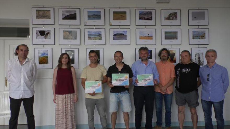 En el centro de la imagen, los tres premios del certamen fotográfico.