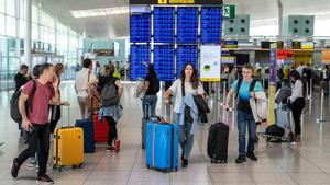 Viajeros con maletas por los pasillos de la Terminal 1 del Aeropuerto de El Prat.