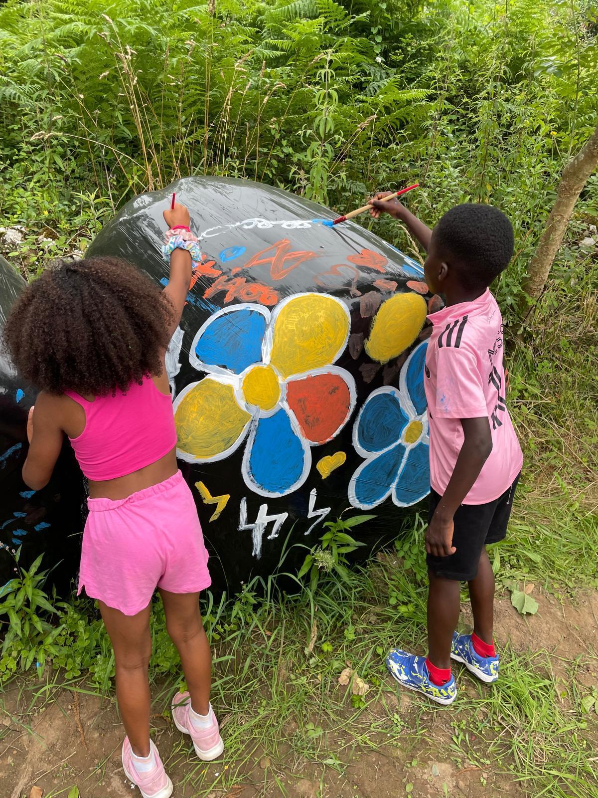 Dos niños, en pleno proceso de pintado de bolas.