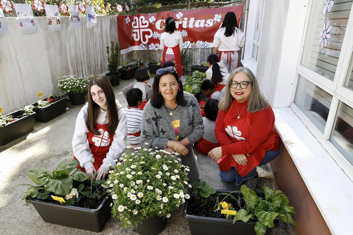 Lucía, Ana y Mar posan junto a los participantes de 'Sembrando valores' en su huerto urbano