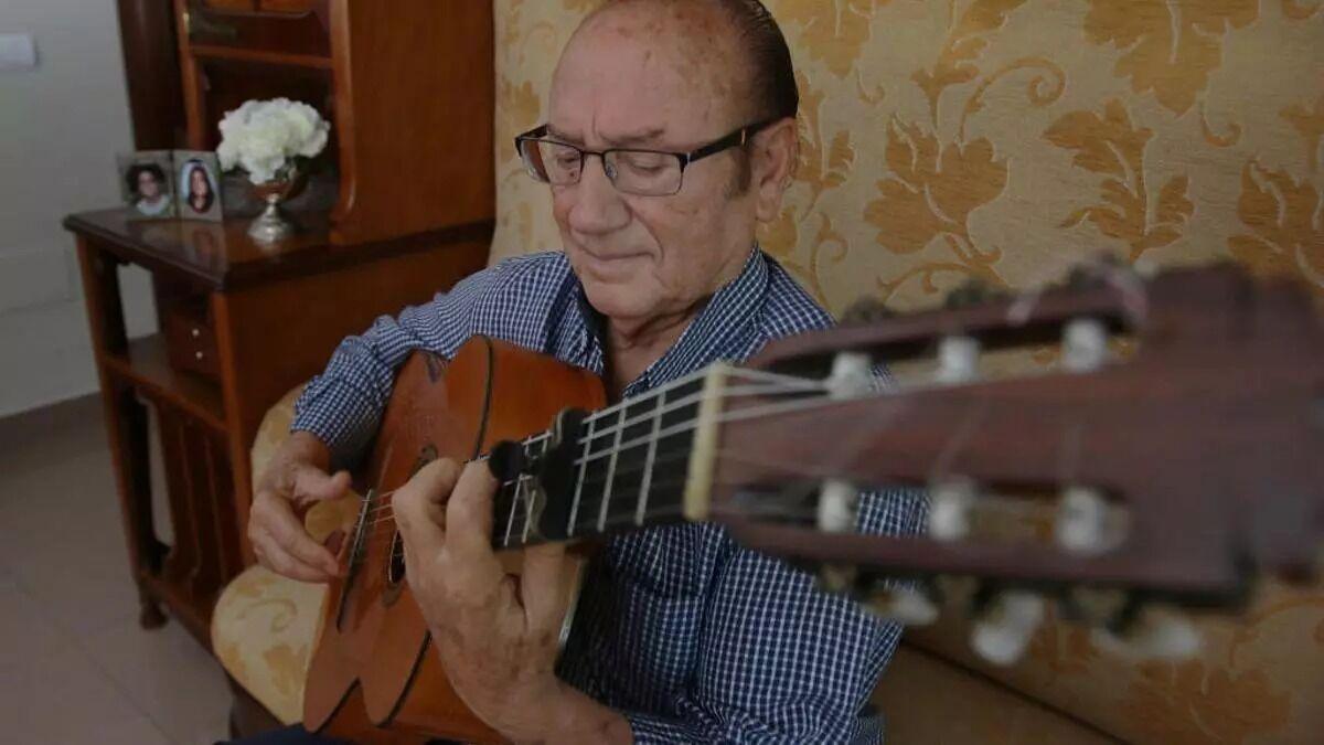 Fosforito toca la guitarra en su casa.