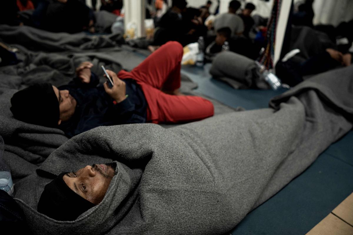 Migrantes descansando a bordo del barco de rescate Ocean Viking de la organización humanitaria marítima europea SOS Mediterranee en aguas internacionales en el golfo de Catania