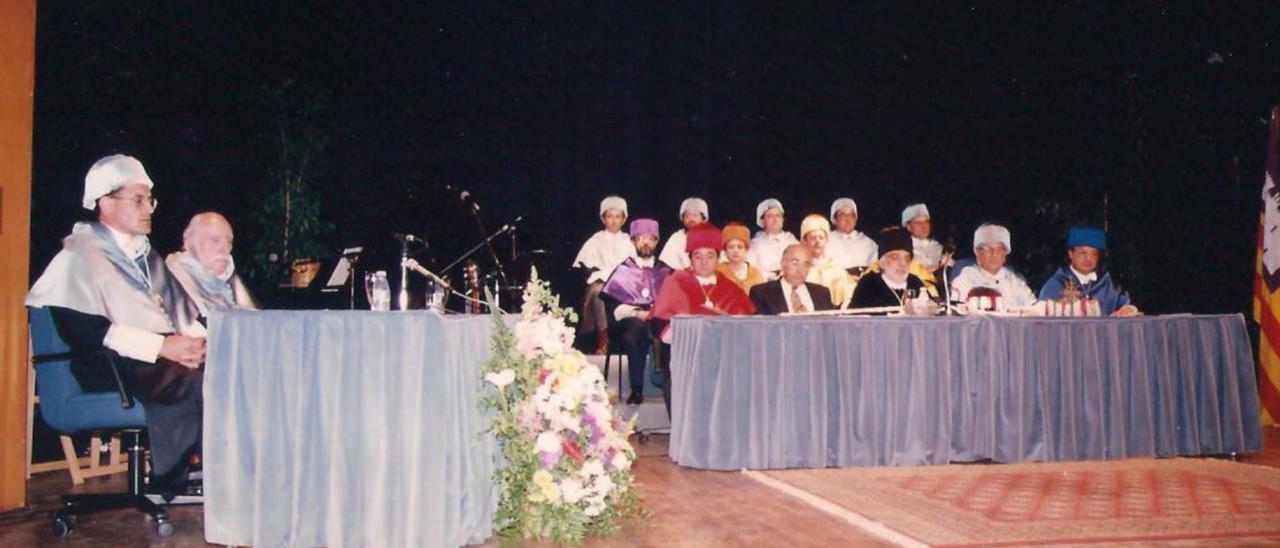 Acte de proclamació de Marià Villangómez com a doctor Honoris Causa de la Universitat de les Illes Balears, l&#039;abril de 1995, a l&#039;Auditori de Cas Serres. És situat el segon per l&#039;esquerra, acompanyat de Joan Mas Vives.