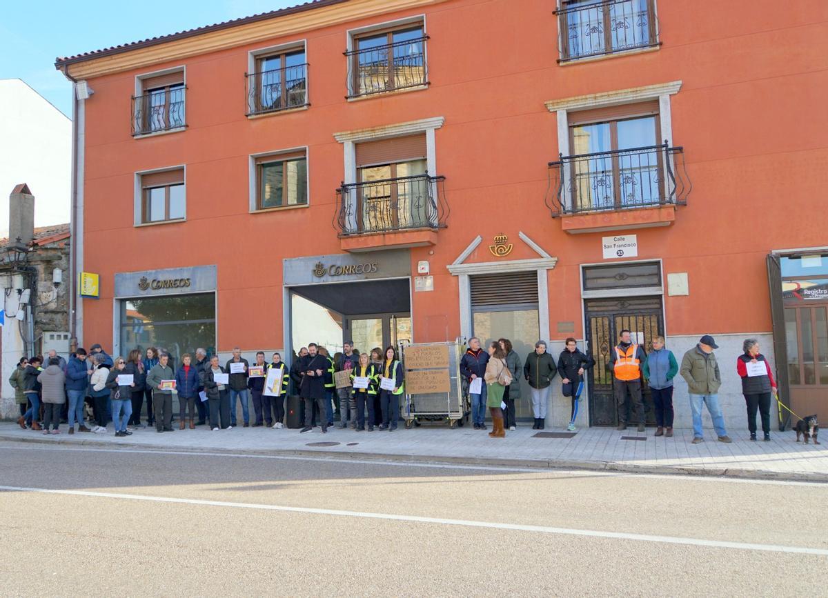 Autoridades y vecinos arropan a los carteros de aliste en el acto de protesta.
