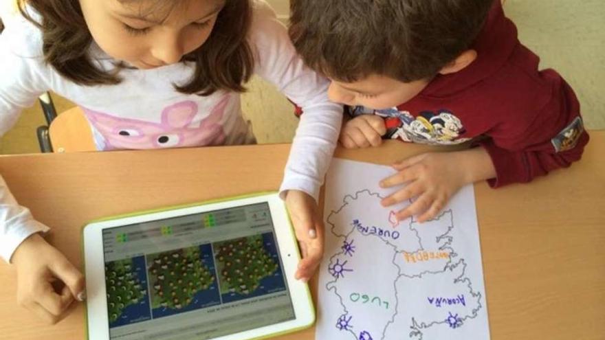 Alumnos de Infantil de un colegio de la comunidad gallega consultan una &#039;tablet&#039;.