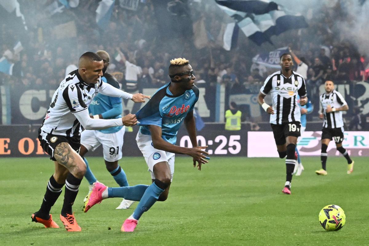 El defensor brasileño del Udinese, Rodrigo Becao (L), detiene al delantero nigeriano del Napoli, Victor Osimhen, durante el partido de fútbol de la Serie A italiana entre el Udinese y el Napoli