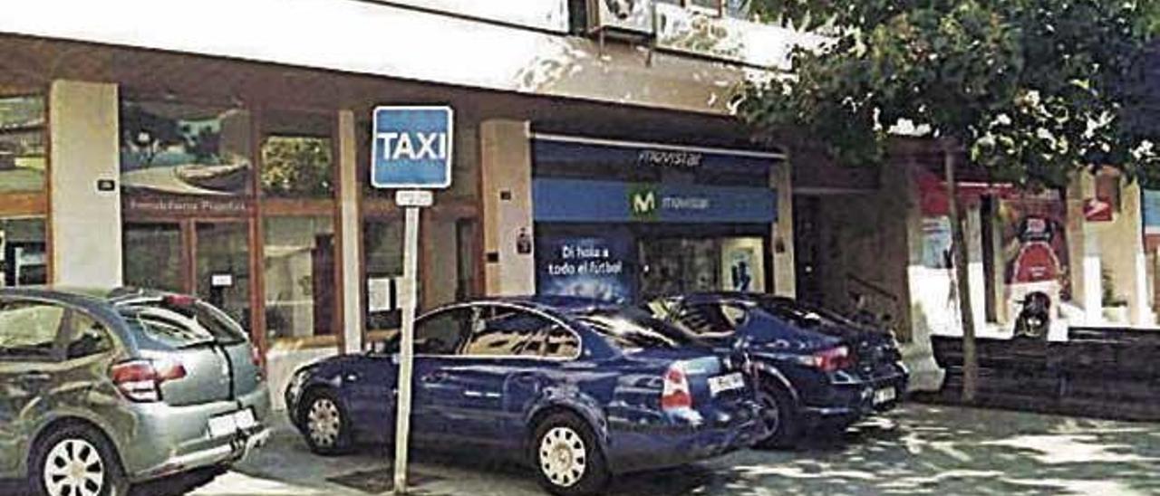 Coches oficiales ocupando la parada de taxis.