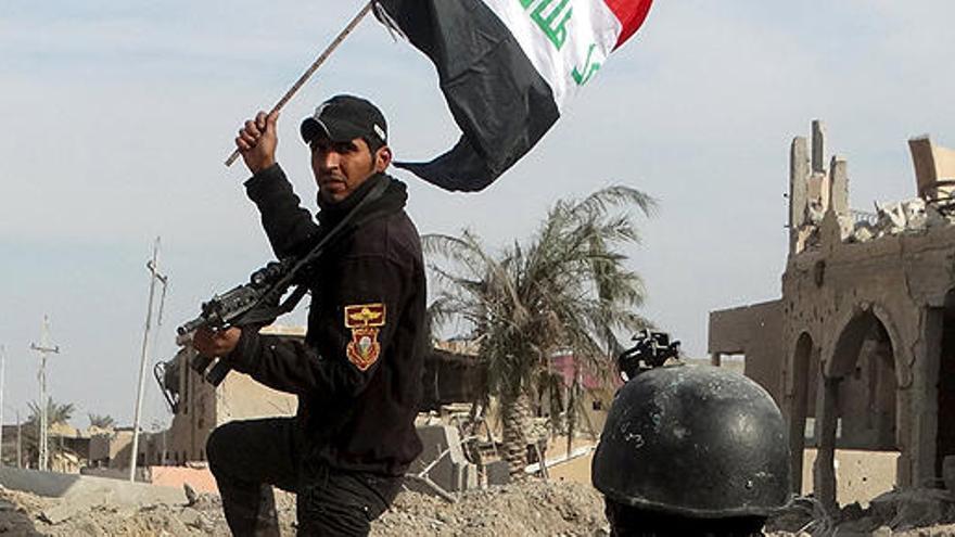 Un soldado iraquí blande una bandera del país en Ramadi.