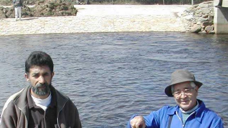 Dos pescadores muestran truchas capturadas en el río Negro.