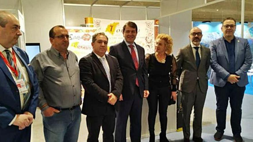 En la imagen de la izquierda, responsables de Torguvi junto al presidente de la Junta de Castilla y León, Alfonso Fernández Mañueco, en el stand de la entidad en Fitur. A la derecha, el presidente de Torguvi, Sergio del Teso, junto al Zangarrón de Sanzoles.