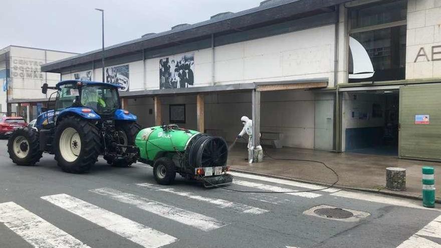 Operarios municipales limpian con la sulfatadora en el exterior de la plaza de abastos. // FdV