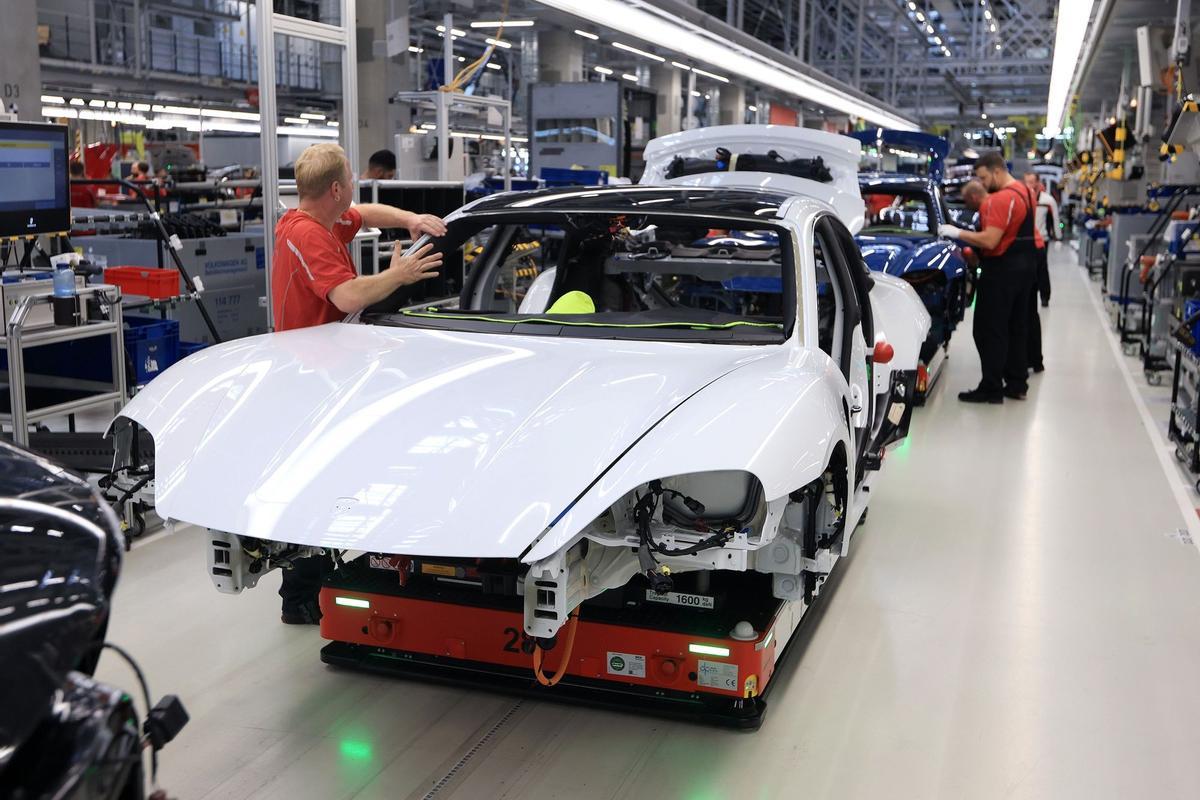 Los empleados trabajan en las carrocerías de los automóviles de lujo Porsche Taycan totalmente eléctricos en la línea de producción de la fábrica de Porsche AG en Stuttgart, Alemania.