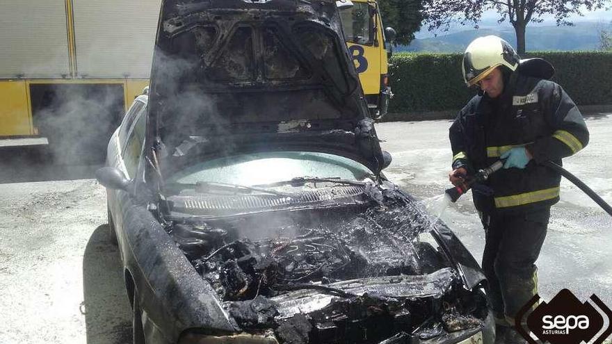 Los bomberos apagan las llamas de un coche que ardió en Tineo