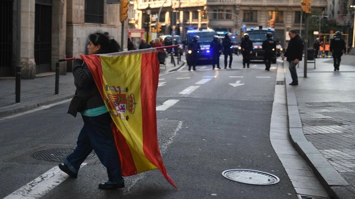 Una mujer exhibiendo una bandera española a la altura de la calle Jonqueres.