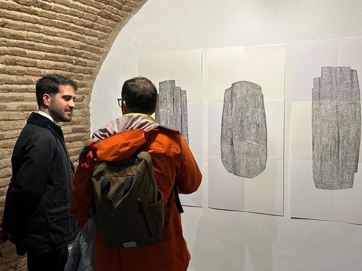 Juanma González (d) le muestra a Diego Avilés su obra.