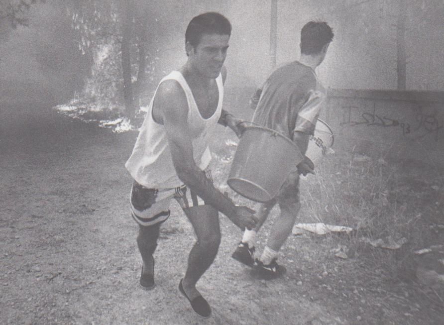Vecinos de La Vallesa combaten el fuego con cubos de agua.