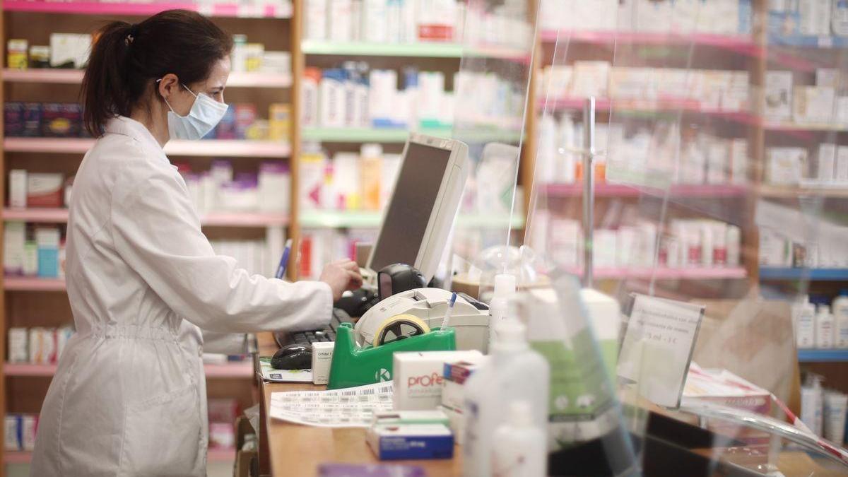 Una farmacéutica despacha en una farmacia