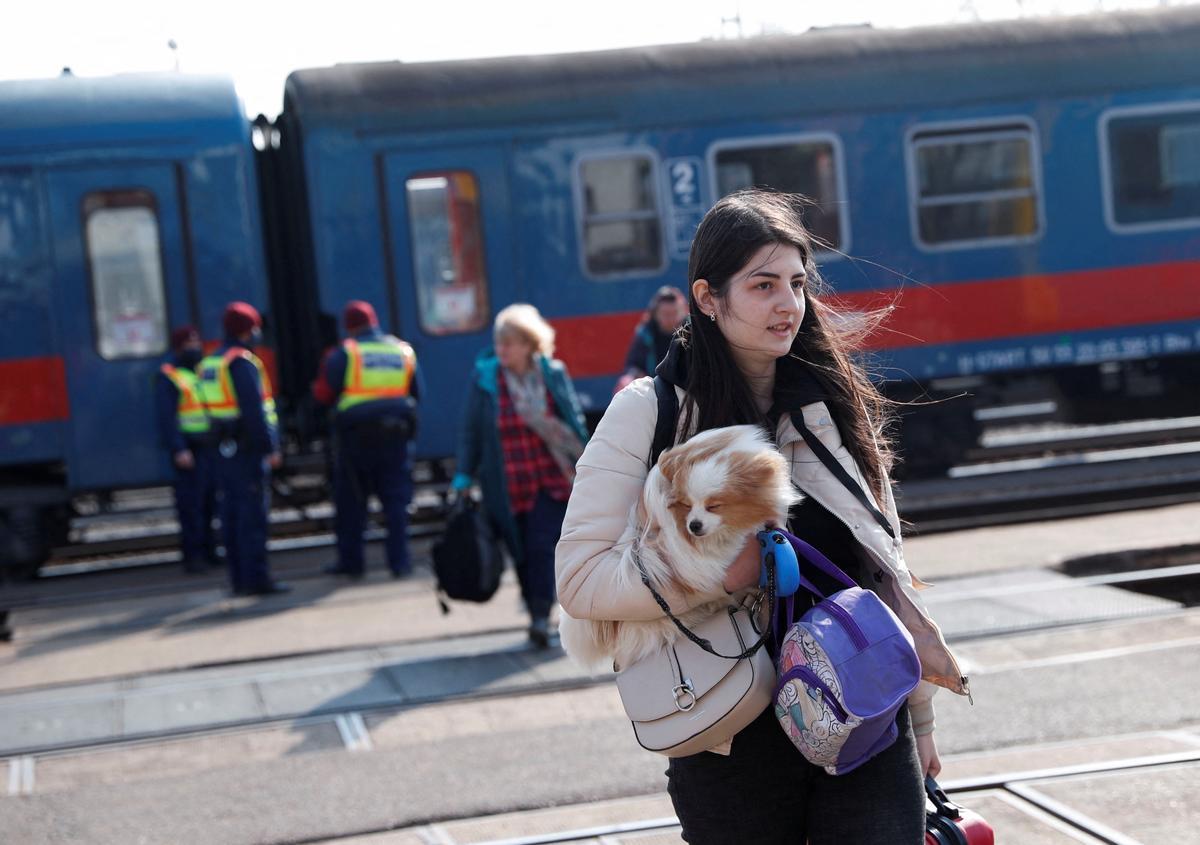 Una mujer y su perro llegan a la estación húngara de Zahony, tras huir de Ucrania.