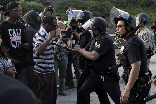 Police confront a crowd of demonstrators on the Interstate 10 freeway as they protest the acquittal of George Zimmerman in the Trayvon Martin trial, in Los Angeles
