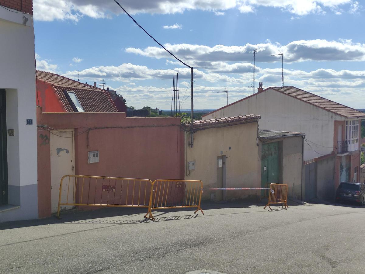 Calle Valdería, con un solar y una vivienda vallados y acordonados para evitar el acceso.