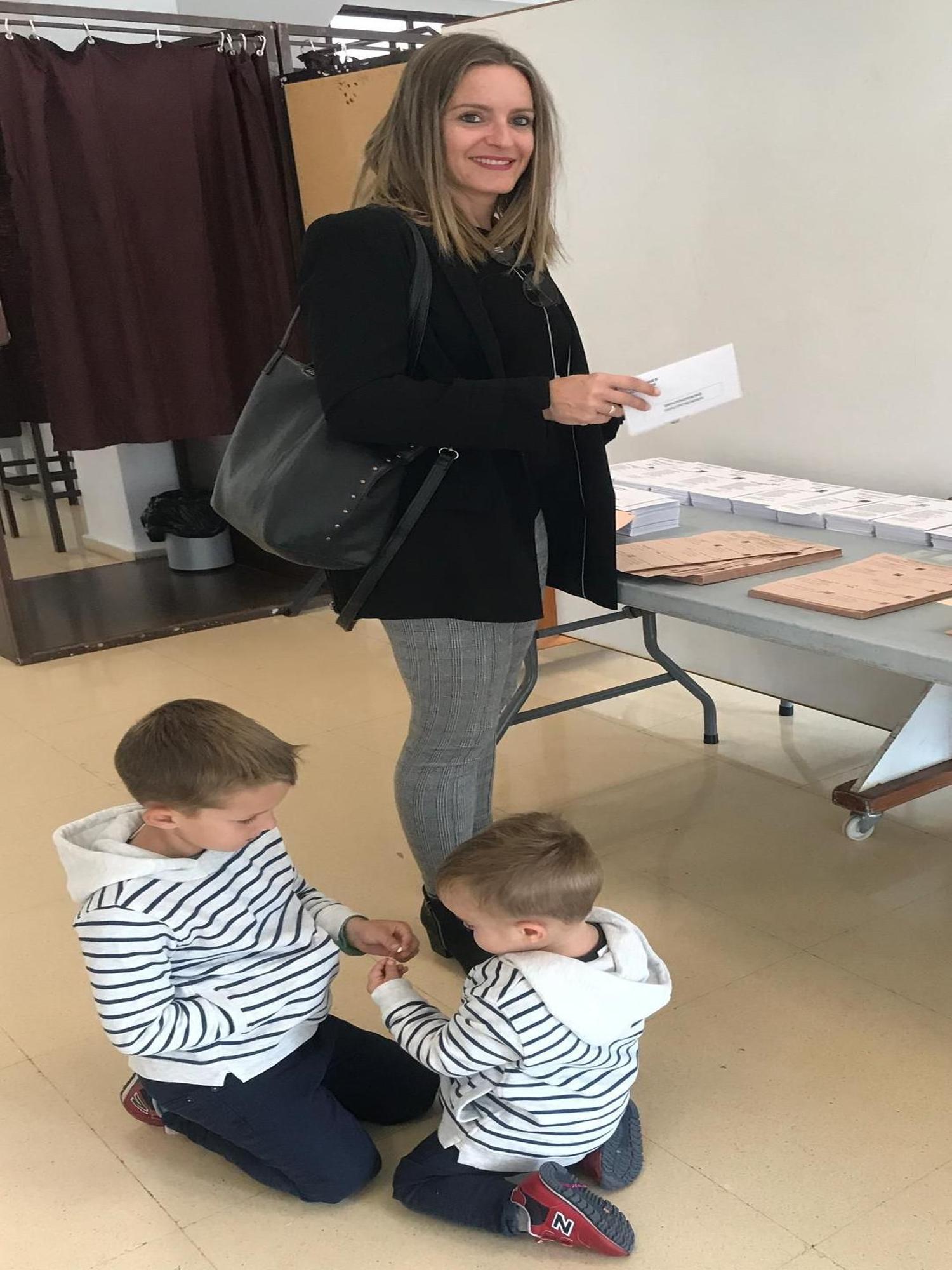 Àngela Ballester votando y sus hijos jugando.