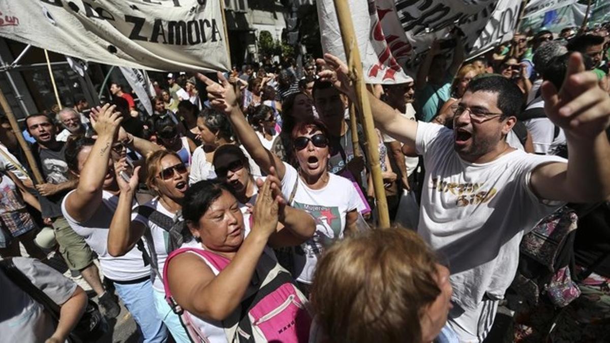 Un grupo de personas se manifiestan en el centro de Buenos Aires, en protesta por los despidos masivos de trabajadores estatales, este miércoles.