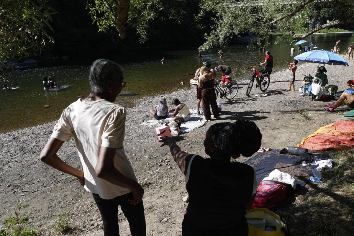 Bañistas este jueves en la playa fluvial a orillas del río Nalón, en Las Caldas.