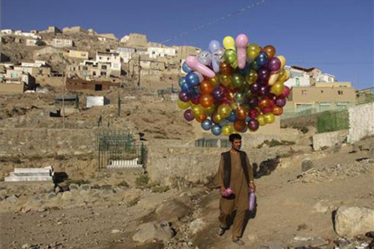 Un home afganès ven globus a Kabul.