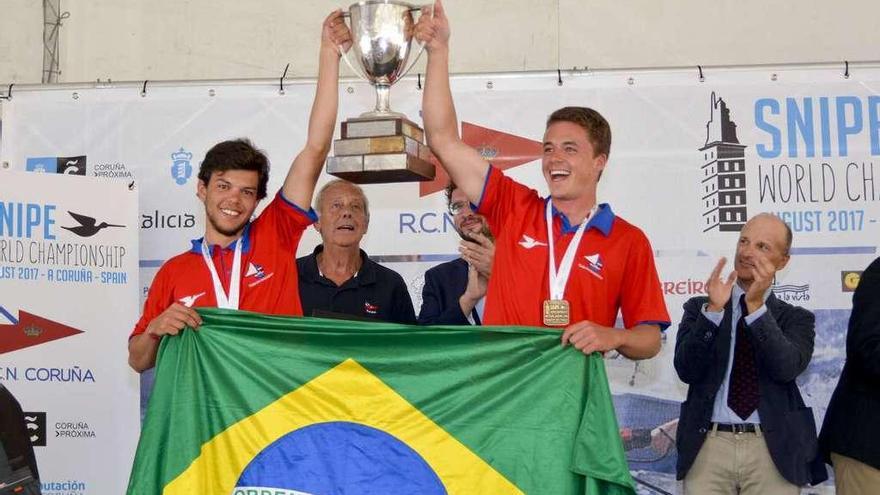 Tiago Brito y su tripulante levantan el trofeo de campeones del mundo.