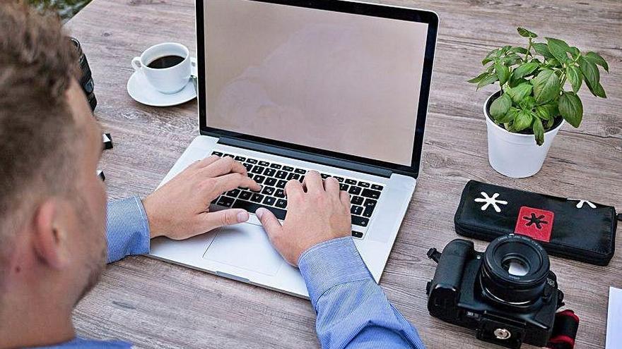 Una persona teletrabajando con su ordenador portátil.