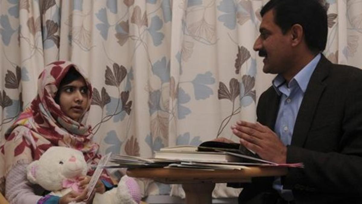 Malala y su padre charlan en la habitación del hospital donde la menor se recupera de las heridas.