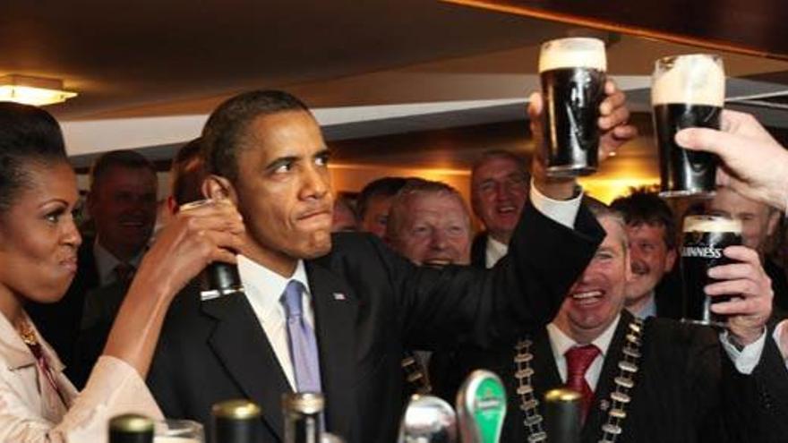 Obama toma una pinta de cerveza junto a su mujer Michelle en un pub de Dublín.